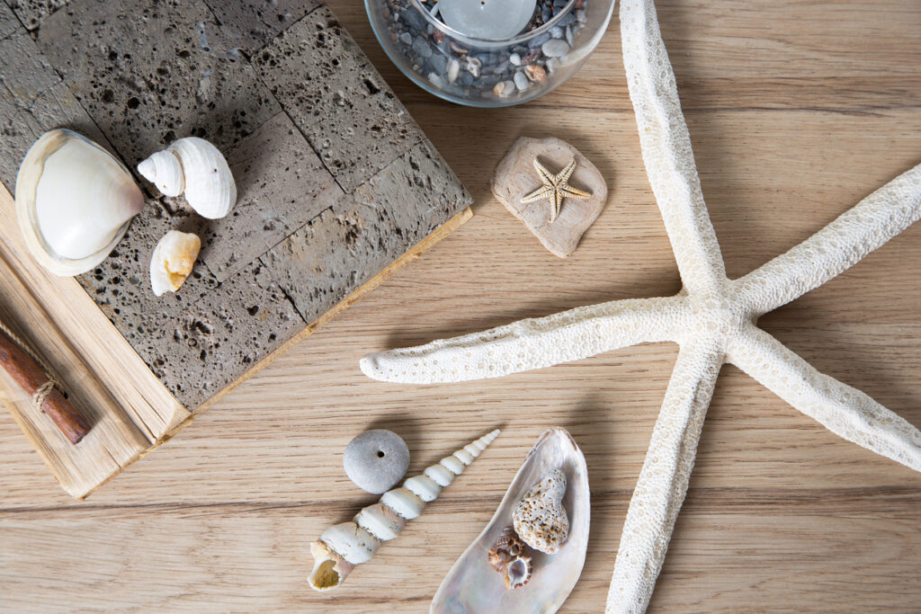 A starfish and seashells are arranged on a wooden table.