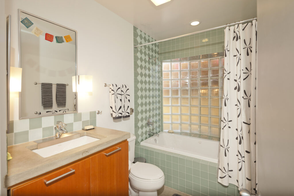 A bathroom with a white sink, toilet, and bathtub. The sink has a mirror above it and a towel rack next to it. 